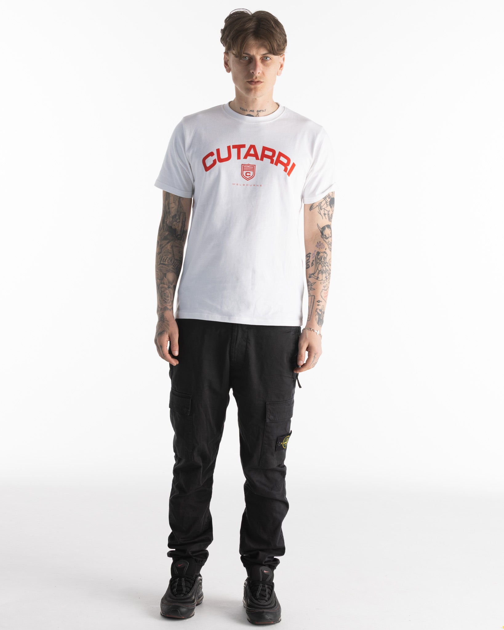 Person wearing a white t-shirt with 'CUTARRI' branding and black pants on a white background
