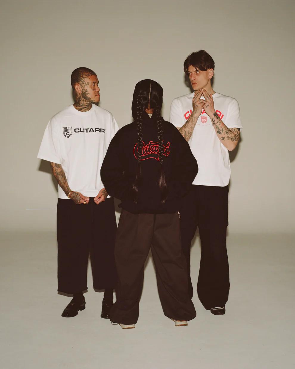 Three people wearing Cutarri clothing on a plain background